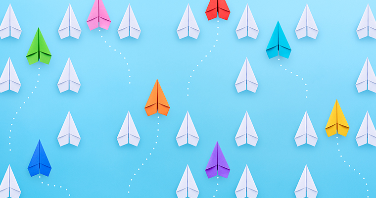 Group of paper planes in one direction and with one group individual pointing in the different way.